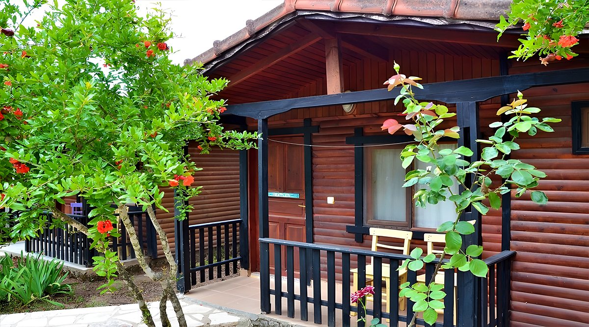 Bungalow Oda: çiçeklerle çevrili ahşap bungalov ve balkonu
